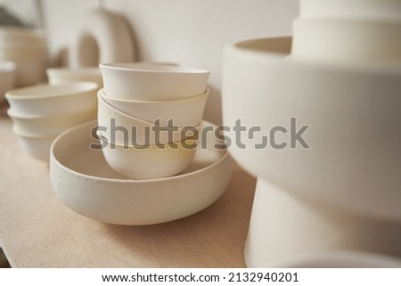 Round ceramic dish and teabowls in pottery studio Royalty-Free Stock Photo #2132940201