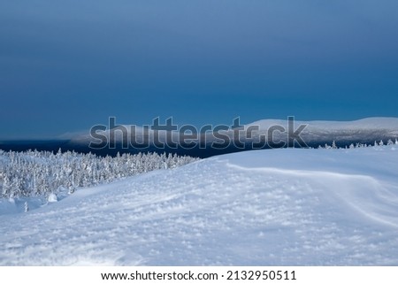 Snow-covered polar cone hills in winter early in the morning. Winter polaris landscape. View of the snow-covered hills. Cold winter weather. Harsh northern climate background.