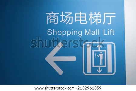 Elevator sign on the wall of mall.(The word on wall is Chinese and English translation  shopping