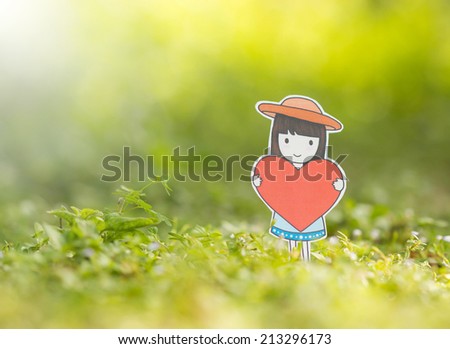 Cute little girl holding red heart in the nature ,creative design paper cut.