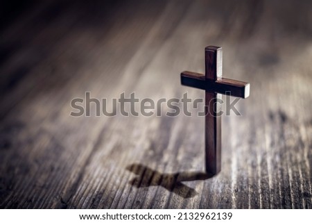 Religious crucifix cross upright on wooden table background with copy space Royalty-Free Stock Photo #2132962139
