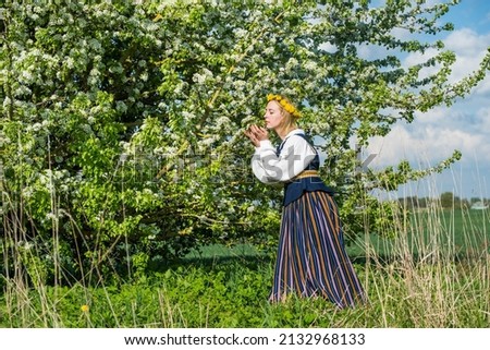 Beautiful feminime woman in national dress with white spring flowers