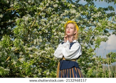 Beautiful feminime woman in national dress with white spring flowers