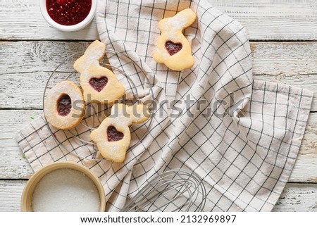 Cooling rack with tasty Easter cookies on white wooden background