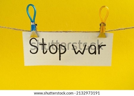 Inscription "stop war" suspended on clips in the colors of the Ukrainian flag on the yellow background. The concept of calling to stop war,  crisis in Ukraine. No war. Stop war. 