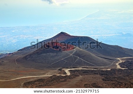 Arid and desert views along the sides of the Etna volcano, with ancient lava flows and effusive rocks on the mountain ridges and secondary craters