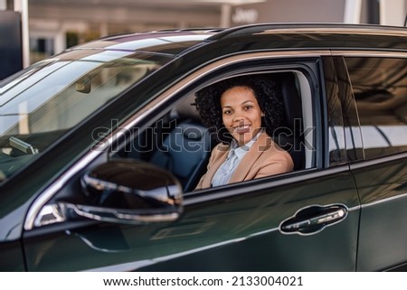 Picture of joyful adult woman, relaxing in her brand new car.