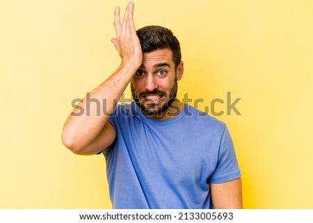 Young caucasian man isolated on yellow background forgetting something, slapping forehead with palm and closing eyes. Royalty-Free Stock Photo #2133005693