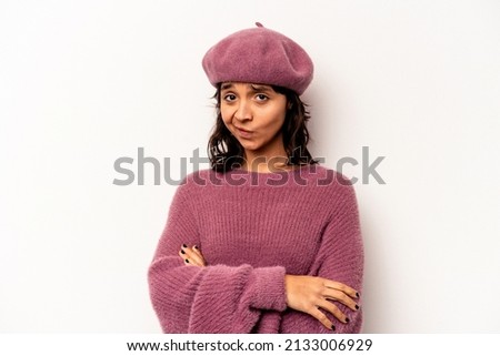 Young hispanic woman isolated on white background suspicious, uncertain, examining you.