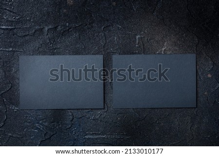 Two black business cards mockup, front and back, on a dark background, a template for design presentation, thick cardboard