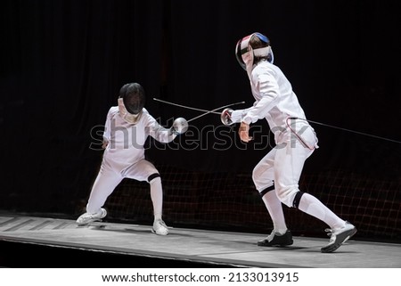 Fencer  with fencing sword. Fencers duel concept Royalty-Free Stock Photo #2133013915