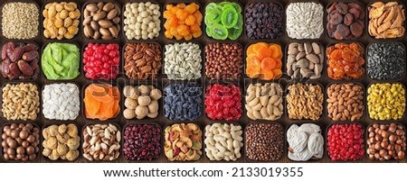 assorted nuts and seeds, various kinds of dried fruits, sun-dried berries. composition organic food background, top view. Royalty-Free Stock Photo #2133019355