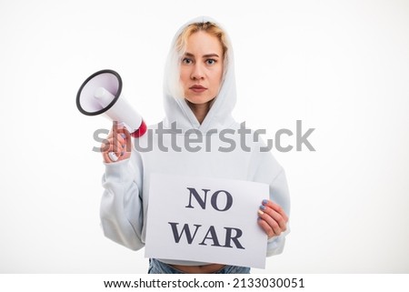 A young woman holds a megaphone and a no war poster