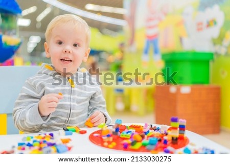 little boy play colorful cubes puzzle at the table.