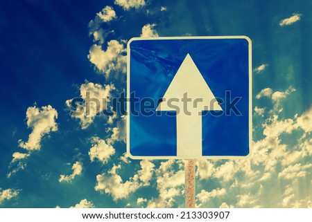 Toned image of directional road sign outdoors against sky