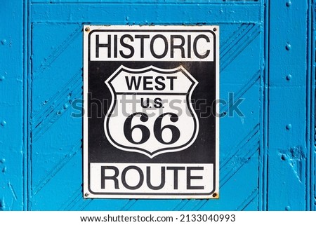 Vintage metal Historic West U.S. Route 66 sign nailed on bright blue wooden door, Albuquerque, New Mexico, USA Royalty-Free Stock Photo #2133040993