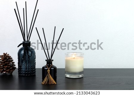 many design of luxury aroma scent reed diffuser glass bottle are on wooden table with scented candle to creat romantic and relax ambient in bedroom with white cement wall background on Valentine day Royalty-Free Stock Photo #2133043623