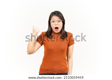Showing and Pointing Product With Thumbs Of Beautiful Asian Woman Isolated On White Background