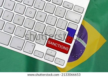 White computer keyboard with button of flag Russia and red button with word of sanctions on Brazil flag background. Financial and economic regulation sanctions Brazil against of Russia Royalty-Free Stock Photo #2133066653