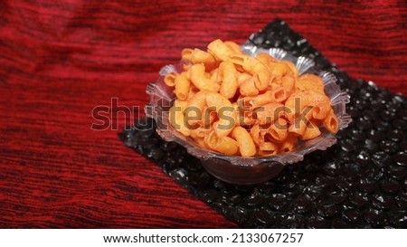 Makaroni pedas or spicy macaroni in a glass bowl. a typical bandung snack served in a plastic jar, delicious and savory snacks. spicy snack in Indonesia.. Royalty-Free Stock Photo #2133067257