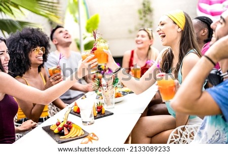 Trendy friends drinking cocktails at poolside party - Young people having fun on luxury resort - Fancy life style concept with guys and girls toasting drinks and fruit together - Bright vivid filter Royalty-Free Stock Photo #2133089233