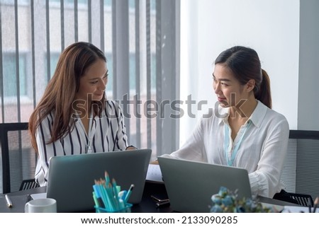 Two Asian female accountant sitting working together in the office.