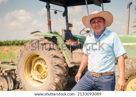 Portrait of a farmer with the tractor behind him. Royalty-Free Stock Photo #2133093089