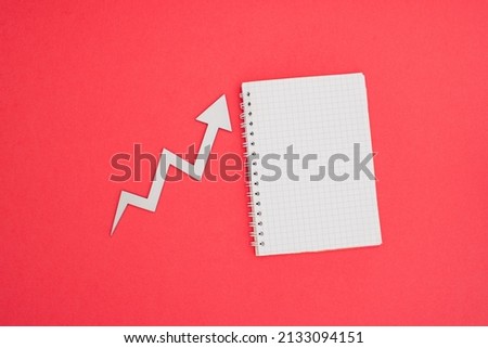Stock market A6 notebook wire binding mock up blank template design idea. Gray growth arrow mockup against pastel pink background. Copy space templates designs for message layout.