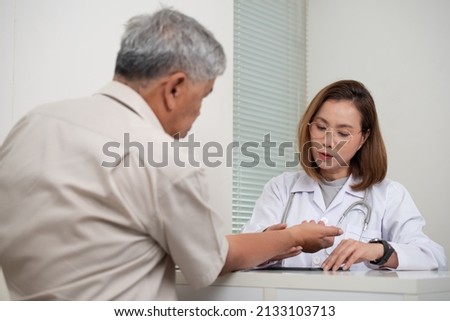 Asian Female Doctor examining old male patient in hospital, Healthcare and Medical concept
