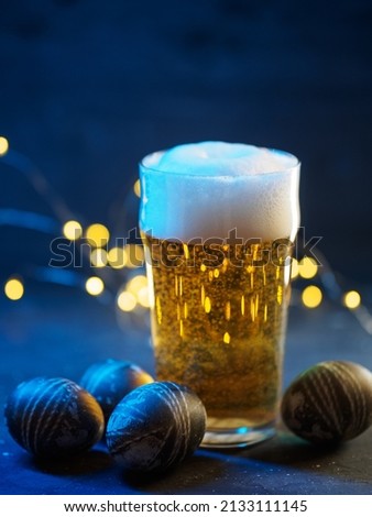 A glass of light beer on the table with Easter eggs for Easter holidays. creative holiday greeting card
