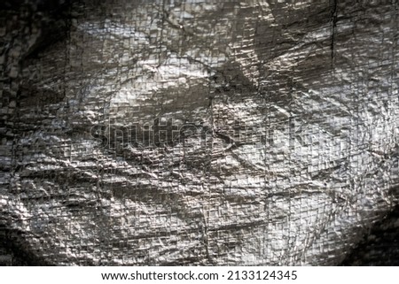 Abstract real fabric surface background. Aluminum Platinum Silver foil Tarpaulin effect with rough texture burlap edge. Futurism 80s retro style new year. Dark Grey black tone design. More in stock