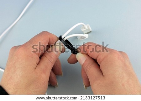 A Black Cable Tie Being Used To Secure Cables Together. Royalty-Free Stock Photo #2133127513