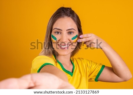 Beautiful caucasian brazilian fan with painted face taking a selfie