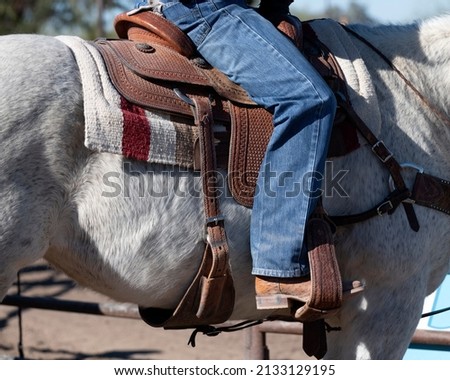 A horse rider leg on a saddle