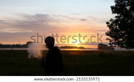 person smoking at sunrise. Clear sky.