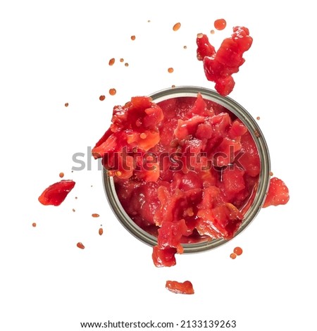 Chopped tomatoes splash from a tin can, top view