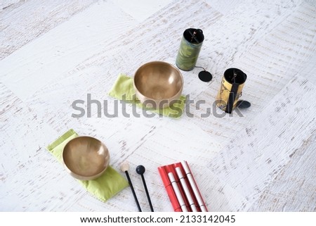 Singing bowls with music materials on white wooden surface for meditation or massage