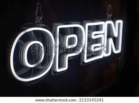 Open neon sign hanging on a window shop