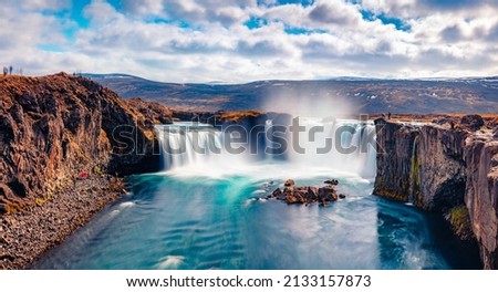 Soft waters of Godafoss - spectacular waterfall plunging over a curved, 12m-high precipice, with paths to various viewpoints. Bright summer view of Skjalfandafljot river, Iceland, Europe.  Royalty-Free Stock Photo #2133157873