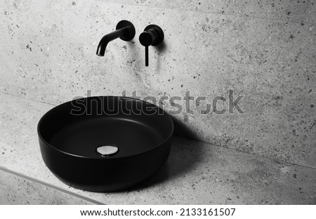 Photo of bathroom details: black matte sink and wall mounted basin tap. Royalty-Free Stock Photo #2133161507