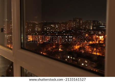 Admiring night view of the city and its night lights, from the window.