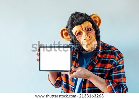 Man in monkey mask using tablet.