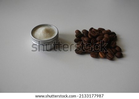 Jar with body skin care cream with coffee beans isolated on white background. Beauty skincare, natural face mask, anti-cellulite cosmetics concept. Top view. Flat lay.