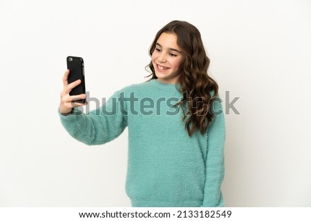 Little caucasian girl isolated on white background making a selfie