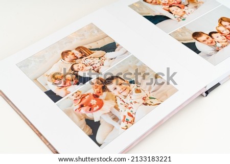 a book with photos of family at home on a white background. Photobook is gift. professional photographer and designer. printing of photos and journals in photo laboratory Royalty-Free Stock Photo #2133183221
