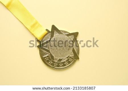 A picture of copyspace gold medal on yellow background. Higher achievement and motivational concept.