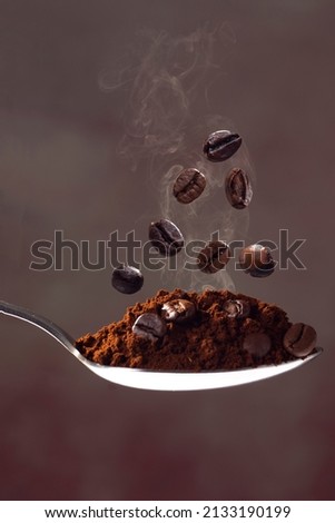 spoon with ground coffee and flying coffee beans Royalty-Free Stock Photo #2133190199