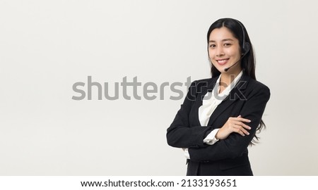 Happy young asian business woman call centre. Welcome female operator put on smalltalk headphone standing on isolated white background. Royalty-Free Stock Photo #2133193651