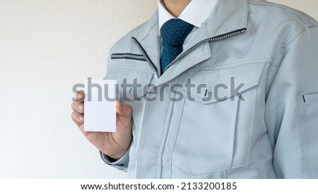 A businessman with a business card. Men in work clothes.