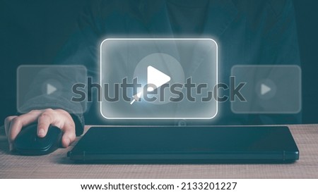 Person using mouse and keyboard watching Video streaming on internet, content online movie or TV ,live concert, show or tutorial on the virtual screen with play button.